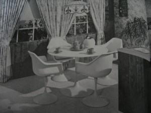 Small dining area off a kitchen is turned to advantage by the handsome background treatment, window deisng and striking modern furniture